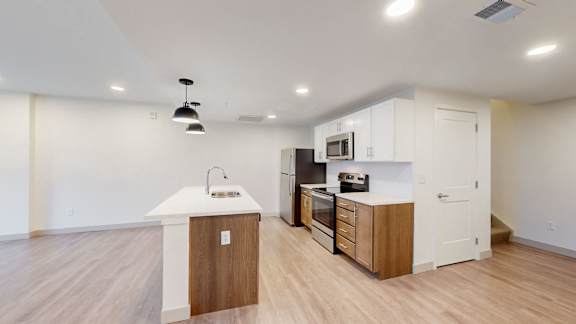 A kitchen with a white counter top and wooden cabinets.
