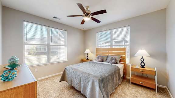 A bedroom with a bed, nightstand, and window at The Slate, Jeffersonville, 47130