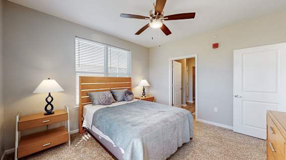 A bedroom with a bed, a ceiling fan, and two lamps at The Slate, Jeffersonville, 47130