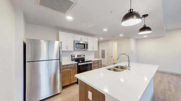 A modern kitchen with a stainless steel refrigerator and a white countertop.