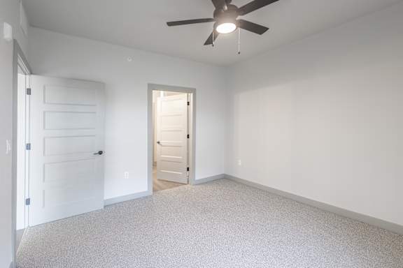 A room with a ceiling fan and two doors at Arbour Place Apartments, Jeffersonville, IN