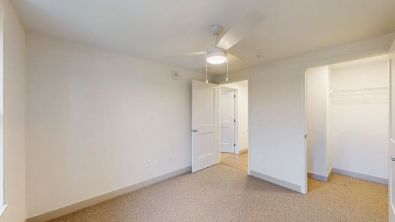 A white room with a carpet floor and a ceiling light.