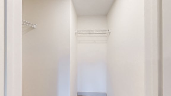 A white hallway with a door on the left and a window on the right.