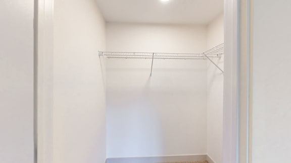 Empty white closet with a shelf.