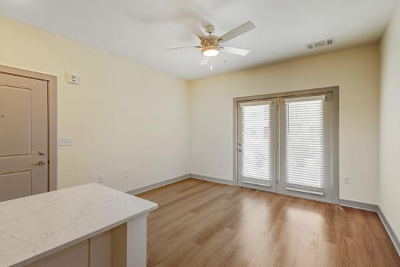A room with a ceiling fan and a table.