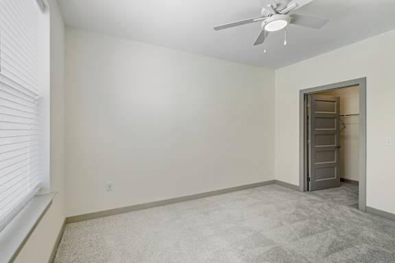 A room with a ceiling fan and a door.