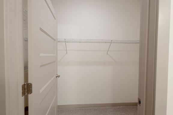 A white closet with a coat hanger.