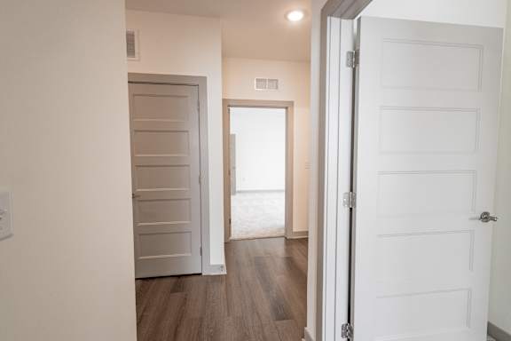 A white door is open to a hallway.