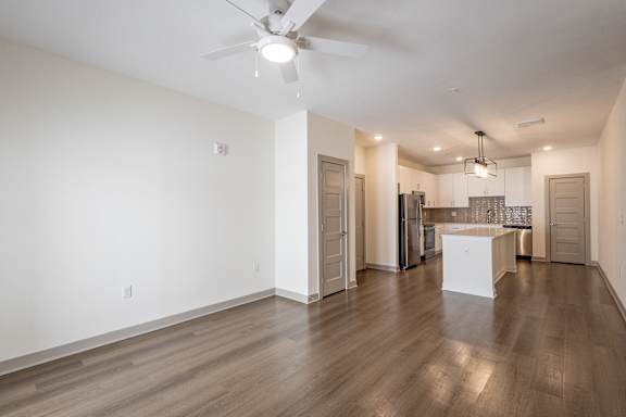 A spacious kitchen with a white island and wooden floors.