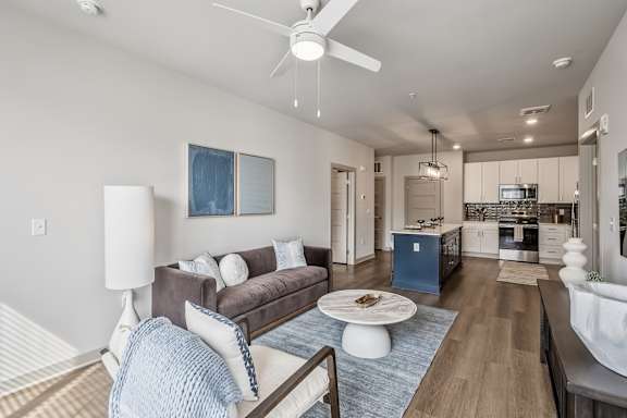 A modern living room with a brown couch and a white coffee table.