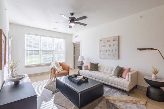 A living room with a couch, a chair, a coffee table, and a ceiling fan at Sage Springs, Elizabethtown, KY