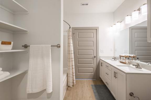 A white bathroom with a towel hanging on the door at Sage Springs, Elizabethtown, KY