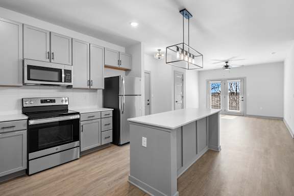A modern kitchen with a large island and stainless steel appliances at Arbour Place Apartments, Jeffersonville