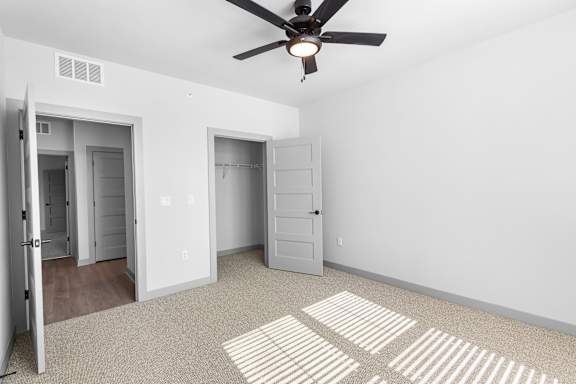 A room with a ceiling fan and two doors at Arbour Place Apartments, Jeffersonville, IN, 47130