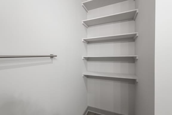 A white shelving unit with five shelves and a metal rail on the left side at Arbour Place Apartments, Jeffersonville, Indiana
