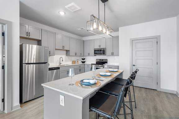 A modern kitchen with a dining table set for two.