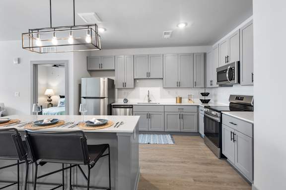 A modern kitchen with a dining table set for two.