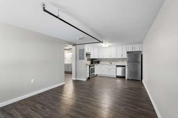 A kitchen with white cabinets and a refrigerator.