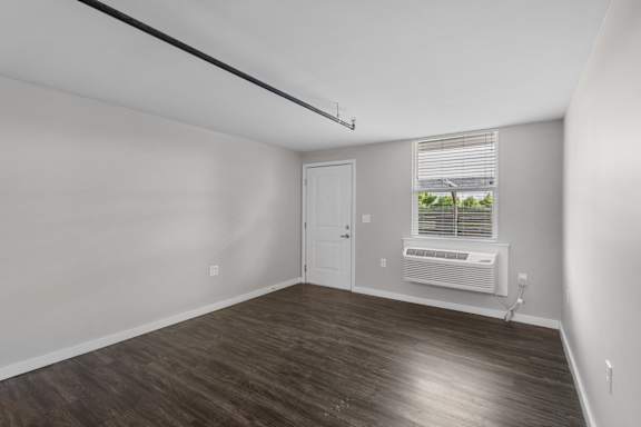 A room with a white door and a window with blinds.