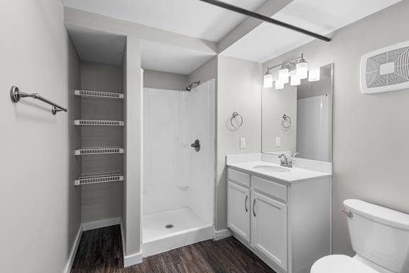 A white bathroom with a walk-in shower and a toilet.