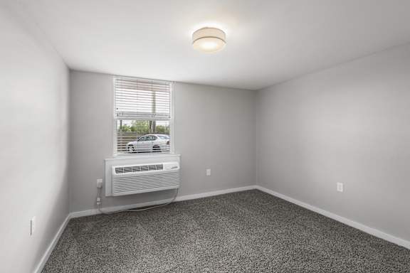 A room with a window and a car outside.