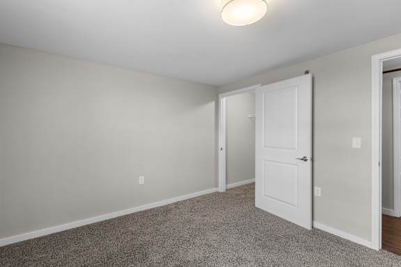 A room with a carpeted floor and a white door.