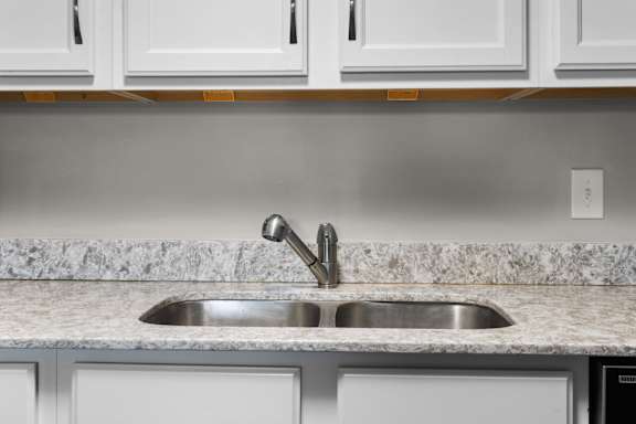 A kitchen with a sink and cabinets.