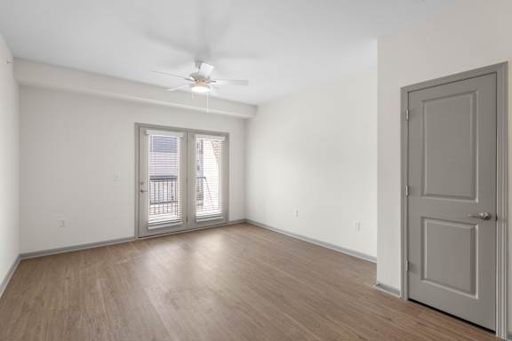 A room with a ceiling fan and sliding glass doors.at Arlington Farms, Greenwood, Indiana, 46143