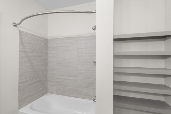 A white bathtub with a shower curtain in a bathroom.at Arlington Farms, Greenwood, Indiana, 46143