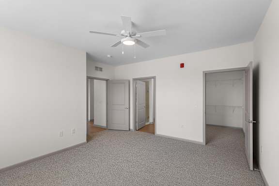 A room with a ceiling fan and carpeted floor.at Arlington Farms, Greenwood, IN, 46143