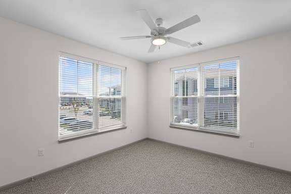 A room with a ceiling fan and two windows.at Arlington Farms, Greenwood, Indiana