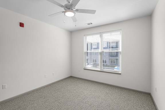 A room with a ceiling fan and a window with blinds.at Arlington Farms, Greenwood, Indiana