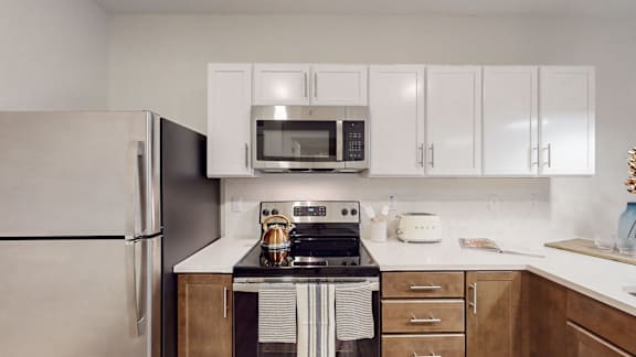 A kitchen with a stove, refrigerator, and cabinets.