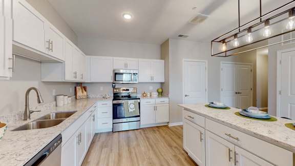 A modern kitchen with white cabinets and a marble countertop at The Slate, Jeffersonville, 47130