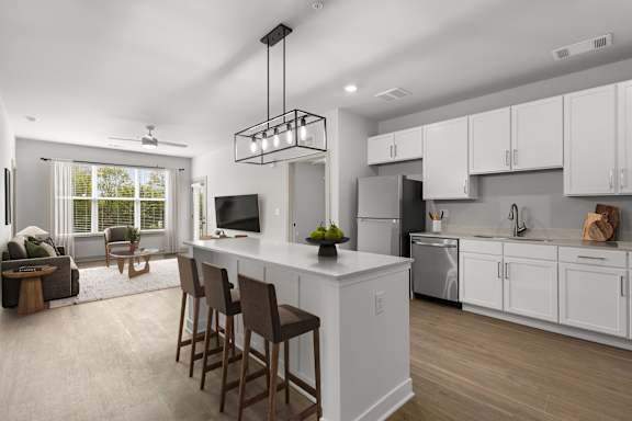 A modern kitchen with white cabinets and a large island.at Forest Edge Apartments, Indiana