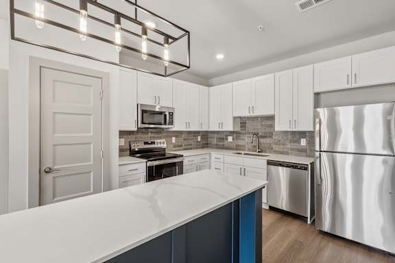 A modern kitchen with white cabinets and a large island.