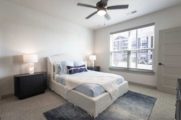 A bedroom with a large bed and a ceiling fan.