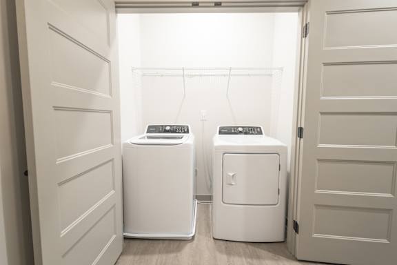 Two white washing machines in a laundry room.