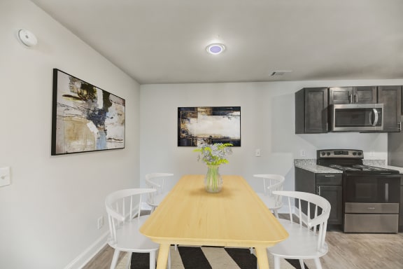 a kitchen and dining room with a wooden table and chairs
