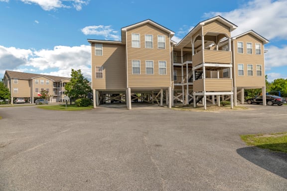 an empty parking lot in front of a row of apartment buildings