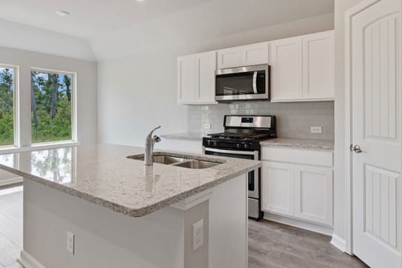 a kitchen with white cabinets and a granite counter top