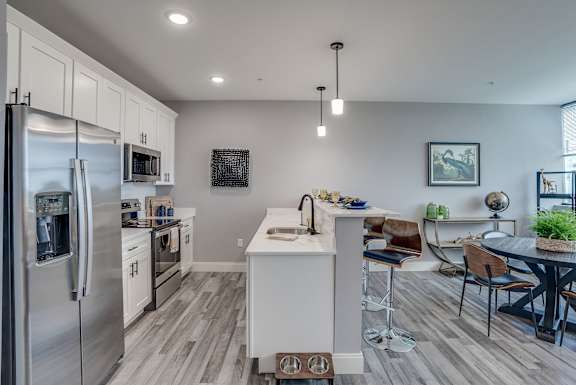 A modern kitchen with a refrigerator, stove, and sink.