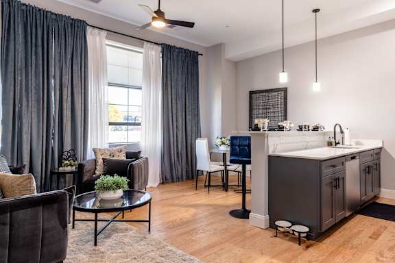 A modern kitchen with a dining area and a living room.