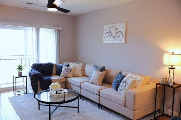A living room with a couch, a coffee table, and a bicycle picture on the wall.