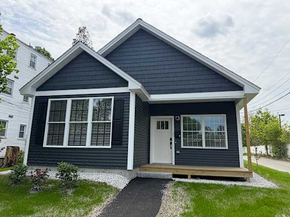 A small house with a white door and windows.