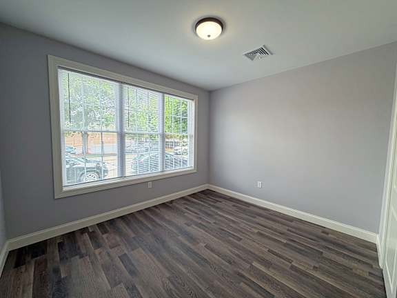 A room with a large window and wooden flooring.