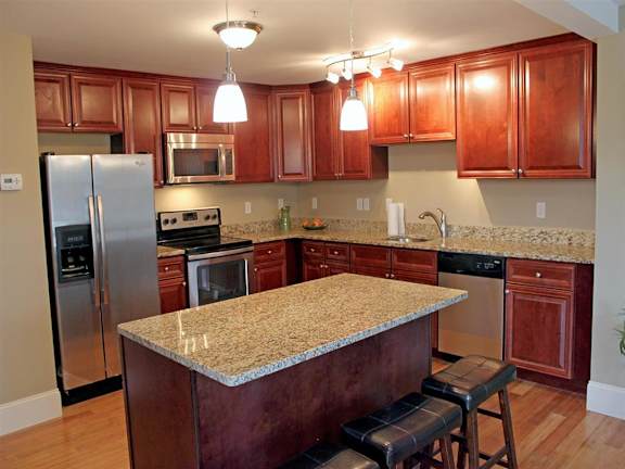 A kitchen with wooden cabinets and granite countertops.