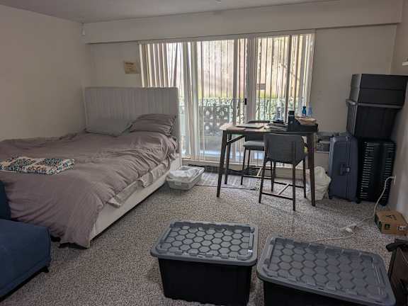 A bedroom with a bed, desk, and chair.