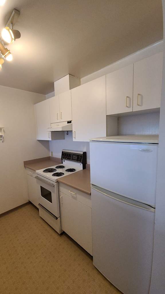 a kitchen with white cabinets and white appliances