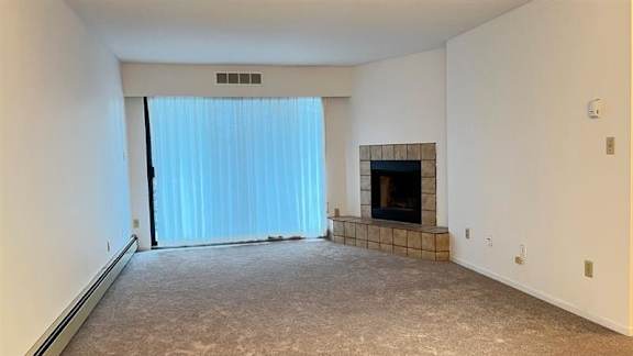 A room with a fireplace and a window with curtains.